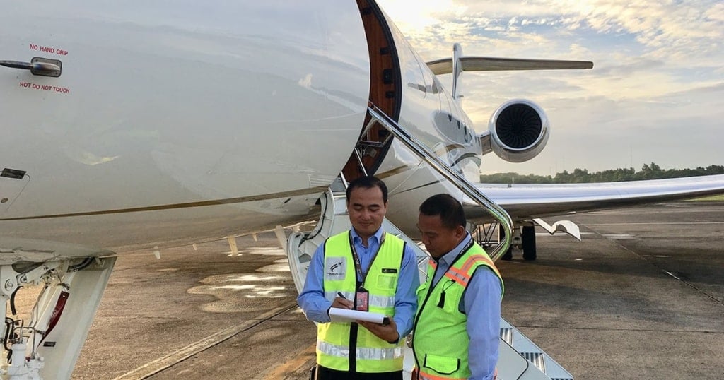 Ground handling team servicing a private aircraft at an Asian airport