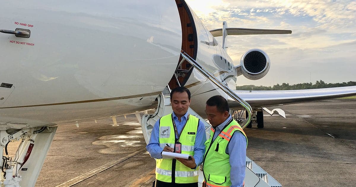 Ground handling team servicing a private aircraft at an Asian airport