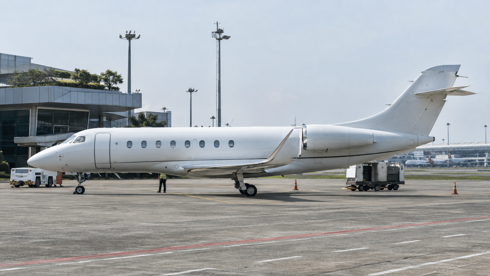 Large-cabin private jet parked on the apron with ground crew, illustrating aircraft positioning costs in Asian private jet charter